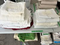 Stacks of assorted sheets and pillowcases on table
