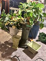 Group view showing both planters, pedestal, white urn with faux flowers, brass urn with pothos