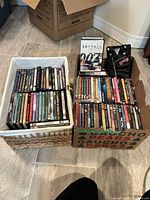 Two containers filled with DVDs and Blu-rays; Skyfall Blu-ray and Grease novelty jacket visible on top