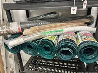 Shelf with green tree guard rolls, wood stakes bundle, black fence rolls