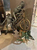 Group shot showing both metal frog sculptures, concrete frog, and two resin fairies