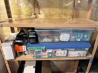 Shelf with two totes, multiple boxed and loose light bulbs