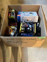 Overview of box showing assorted boxed lights, lantern and lenses
