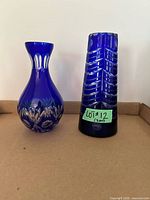 Both cobalt blue cut glass vases side by side