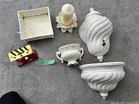All items laid out: two wall pockets, urn, square dish, candle on holder, desk tool set