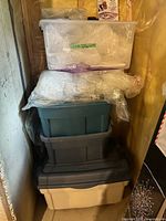 Stack of four plastic totes with bubble wrap visible