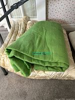 Green fleece blanket folded on floor