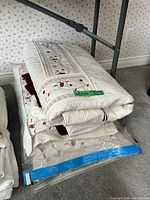 Folded quilted coverlet atop other bedding items