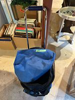 Top view of blue trolley bag showing telescoping handle and flap