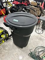 Full view of Rubbermaid Roughneck wheeled trash can with lid and handle visible