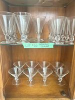 Cabinet view showing goblets on glass shelf and coupes below