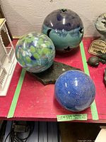 Three ceramic spheres displayed on red surface