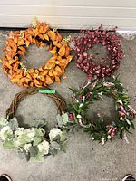 Group shot of four different artificial wreaths on concrete floor
