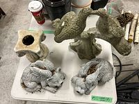 All four concrete statues on table