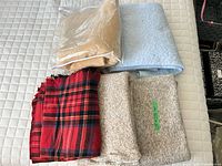 Five folded throw blankets showing colors and patterns