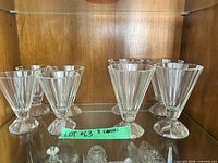 All eight clear faceted dessert glasses arranged on shelf, showing overall condition and design.