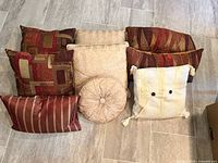 All nine pillows laid out showing variety of patterns, shapes and sizes