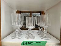 Front view of all nine faceted wine glasses on shelf