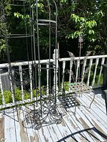 Multiple wrought iron trellises and plant stands on deck