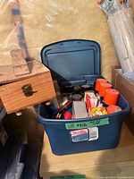 Blue Sterilite tote filled with shoe care items; wooden shine box visible