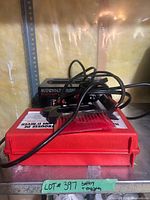 Battery charger on top of red emergency kit case with snow brush visible