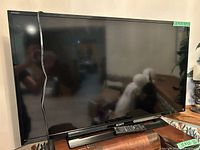 Front view of Sony 40-inch TV with remote placed on stand