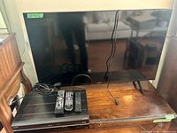 Front view Sony TV, Toshiba unit, three remotes on top