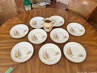 Group shot showing eight plates and pitcher
