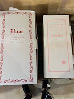 Closed boxes labeled Hope and Jennifer showing branding and wear
