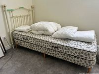 Full view of assembled twin bed with mattress, box spring, headboard and bedding