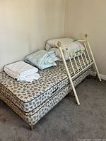Entire bed set with folded bedding and footboard/frame visible
