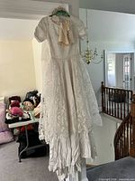 Full view of hanging lace wedding dress showing style and length