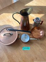 All six copper cookware items arranged on table