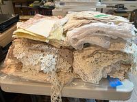 Stacked pile of crochet lace, embroidered linens, napkins