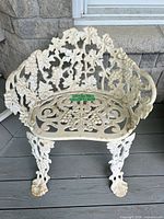 Front view showing ornate grapevine backrest, seat pattern and overall form