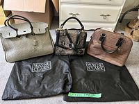 All three handbags with two dust bags visible