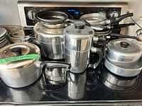 Group shot of all pots, pans and lids on stovetop