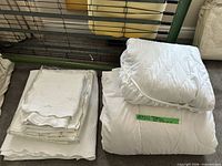 Stacked bedding showing duvet insert and mattress pad on right, coverlet and shams on left