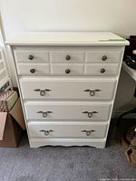 Front view of white dresser showing drawer configuration and hardware