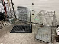 Two wire dog crates side by side showing overall forms and trays