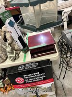 Tabletop view showing green hanging feeder, burgundy tray component, boxed feeding station