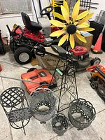 Overview of trellis with sunflower, three planters, cylindrical stand and plaque
