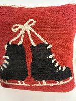 Front view of red hooked pillow with black skates graphic