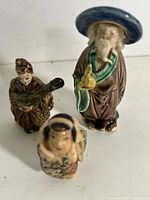 Front view of three Chinese mudmen figurines