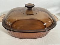 Front view of Corning Ware Visions amber oval casserole with lid