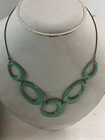 Full view of necklace on bust showing all five enamel oval links