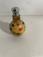 Front view of single art glass shaker showing dot pattern and cap
