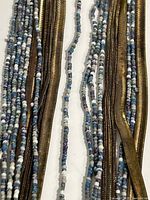 Close-up of mixed seed-bead and bronze-tone snake chain strands