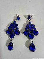 Front view of pair of blue rhinestone chandelier earrings