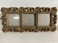 Front view of ornate triple frame showing three openings and full border